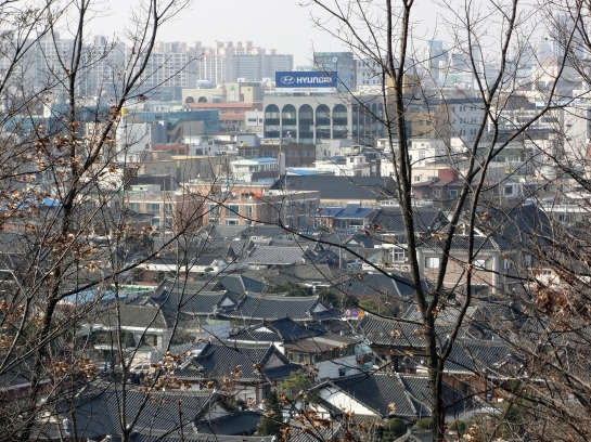 The Hyundai logo among traditional Korean houses